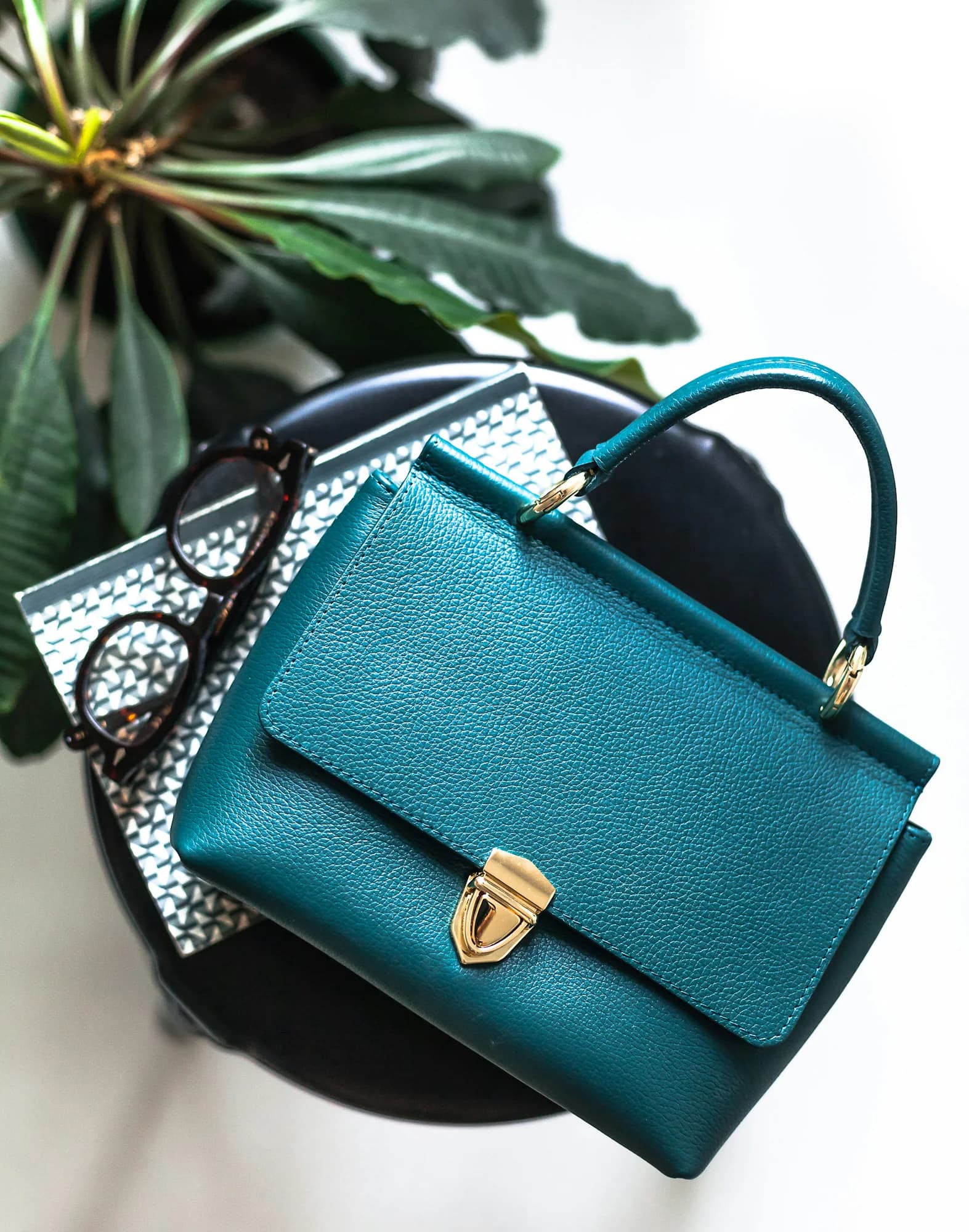 Teal leather satchel bag with a gold push-lock