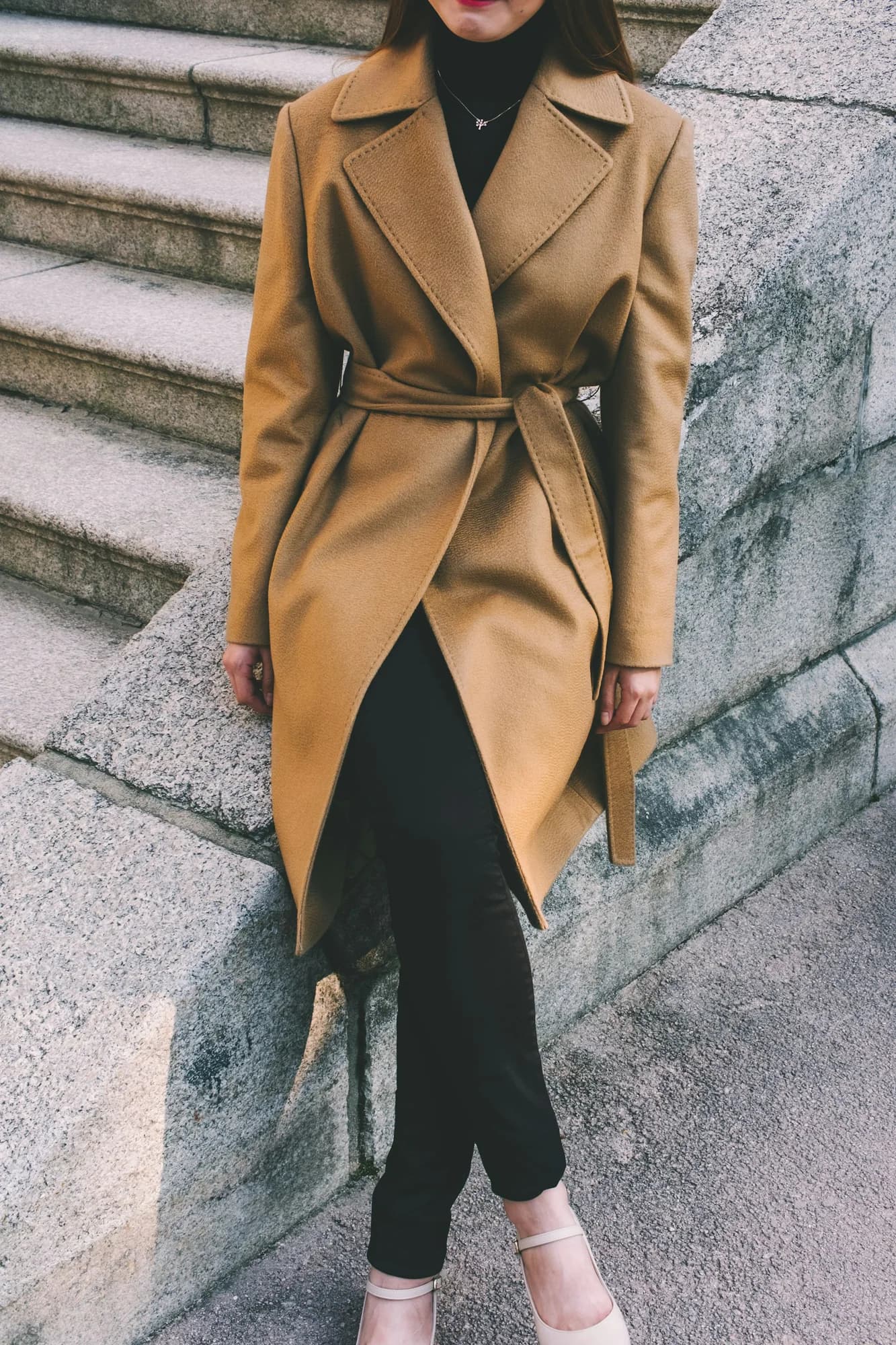 Person wearing a belted camel trench coat